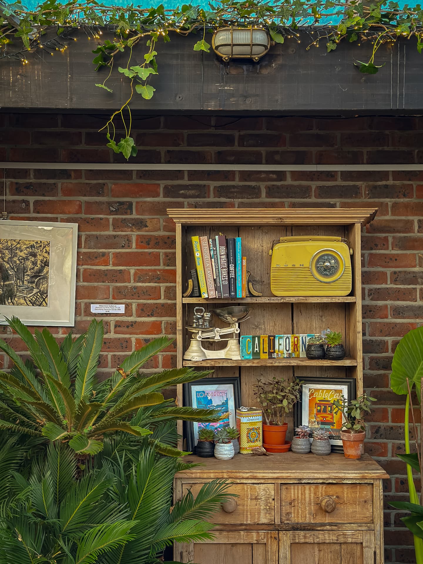 Vintage wooden dresser with cookbooks, a yellow radio and California plates at Midpines
